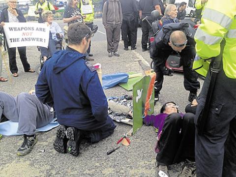 The police have dismantled the lock-on box and exposed the arm tube that Jo (right) and Chris (left) are locked-on to.  PHOTO: NINA CARTER-BROWN