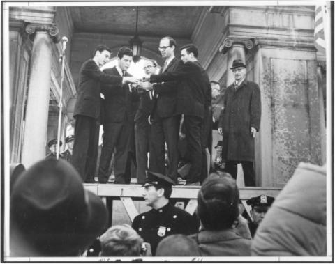 AJ Muste (right) supports five young men burning their draft cards at the Union Square Pavilion in New York City, 6 November 1965.