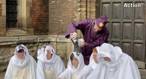 Five activists dressed in white have 'oil' poured on them by someone representing 'Shell'.