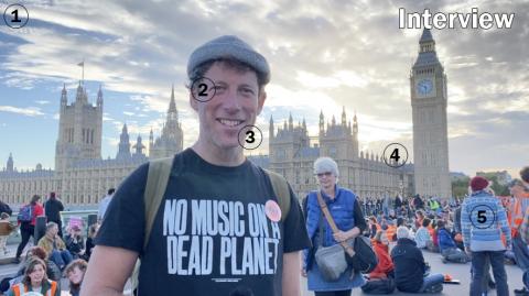 The image is a still from a video interview by Zoe of activist Sam Lee at the Just Stop Oil blockade of Westminster Bridge, 1 October 2022. The photo has numbers on it identifying different aspects of the video.