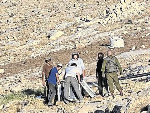 On 3 July, Israeli settlers cut the water pipe supplying the Palestinian village of Umm al-Khair. They also destroyed the village’s water pump, watched by Israeli soldiers. Photo: Villages Group